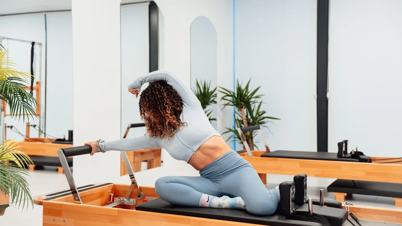 Mulher praticando Pilates no Reformer em estúdio moderno em Votorantim